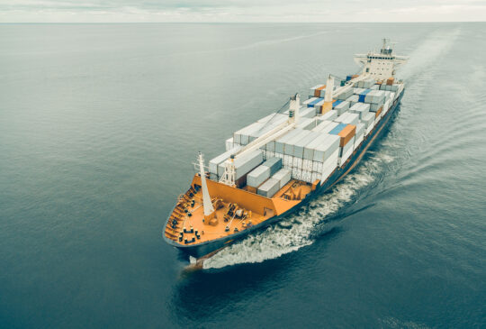 Aerial view of cargo ship sailing in open sea